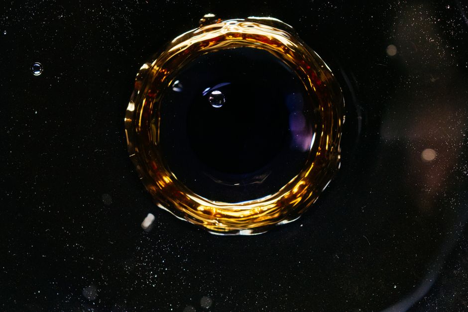 Gota de aceite dorado sobre una superficie oscura